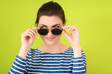 Image showing woman in sunglasses posing in front of a green background