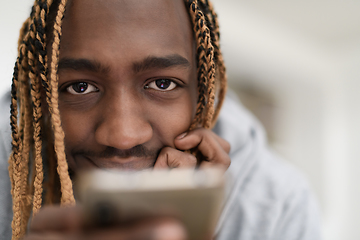 Image showing afro guy uses a cell phone and browses social media during a pandemic