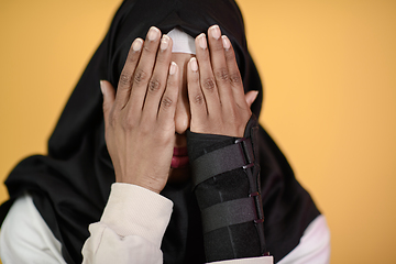 Image showing african muslim woman wearing hijab and traditional muslim clothes posing in front of green background