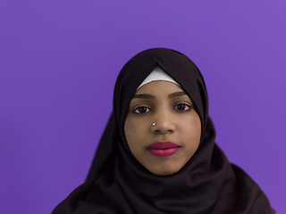 Image showing portrait of african muslim woman wearing hijab and traditional muslim clothes posing in front of purple background