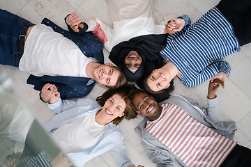 Image showing top view of a diverse group of people lying on the floor and symbolizing togetherness