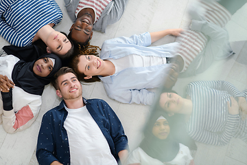 Image showing top view of a diverse group of people lying on the floor and symbolizing togetherness