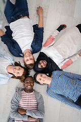 Image showing top view of a diverse group of people lying on the floor and symbolizing togetherness