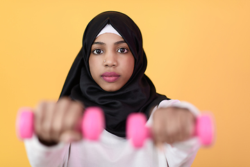 Image showing afro muslim woman promotes a healthy life, holding dumbbells in her hands