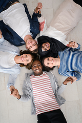 Image showing top view of a diverse group of people lying on the floor and symbolizing togetherness