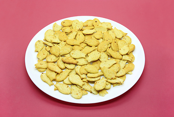 Image showing Fish-shaped cookies in a white plate on a crimson background 