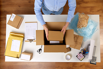 Image showing woman packing fragile parcel boxes at post office