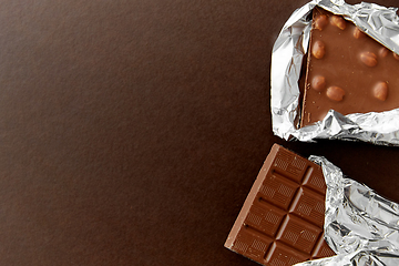 Image showing milk chocolate bar with nuts in foil wrapper