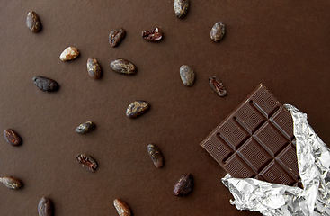 Image showing dark chocolate bar in foil wrapper and cocoa beans