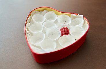 Image showing one candy in red heart shaped chocolate box