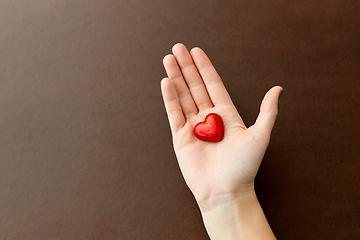 Image showing hand with red heart shaped chocolate candy