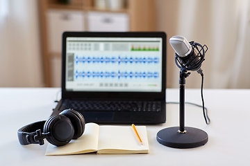 Image showing microphone, laptop, headphones, notebook on table