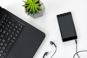 Image showing close up of laptop, smartphone and earphones