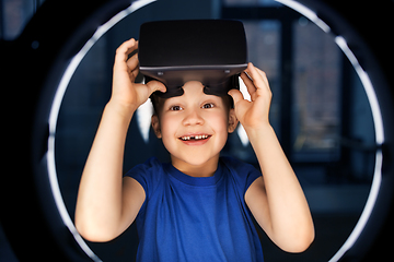 Image showing boy in vr glasses over illumination in dark room