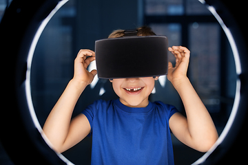 Image showing boy in vr glasses over illumination in dark room