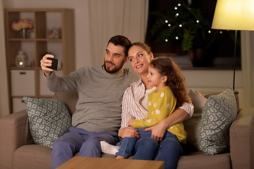 Image showing happy family taking selfie at home at night