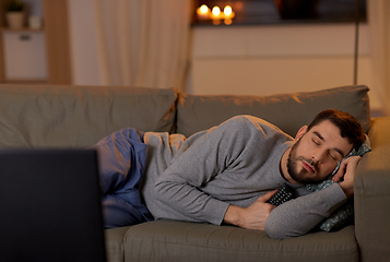 Image showing man sleeping on sofa with tv remote at home