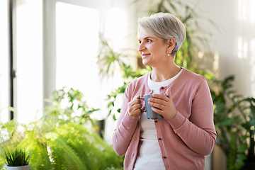 Image showing happy senior woman with cup of tea at home