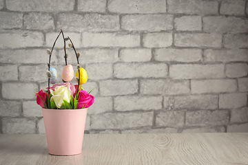 Image showing Flowers, willow twigs and easter eggs in basket in as Easter gift