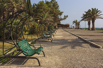 Image showing Deserted swing benches in a city park at a seaside resort