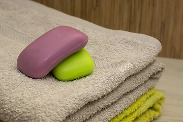 Image showing A couple of bars of aroma soap on a terry bath towel