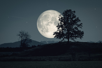 Image showing moon and stars over dark scenery