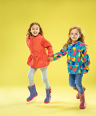 Image showing A full length portrait of a bright fashionable girls in a raincoat