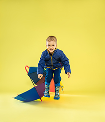 Image showing A full length portrait of a bright fashionable kid in a raincoat