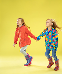 Image showing A full length portrait of a bright fashionable girls in a raincoat