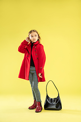 Image showing A full length portrait of a bright fashionable girl in a raincoat