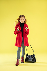 Image showing A full length portrait of a bright fashionable girl in a raincoat