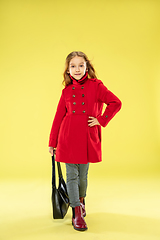 Image showing A full length portrait of a bright fashionable girl in a raincoat