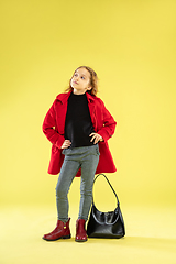 Image showing A full length portrait of a bright fashionable girl in a raincoat