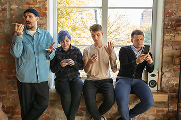 Image showing Group of happy young men and women sharing in social media