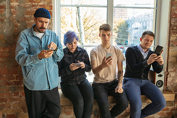 Image showing Group of happy young men and women sharing in social media