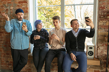 Image showing Group of happy young men and women sharing in social media