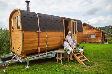 Image showing three girls relaxing outside sauna