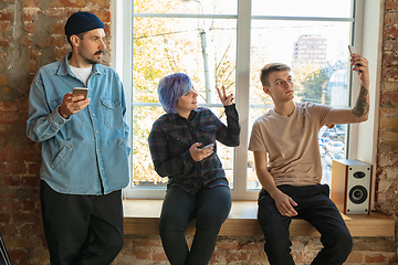 Image showing Group of happy young men and women sharing in social media