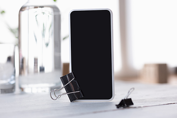 Image showing Mock up empty black smartphone screen on blured background