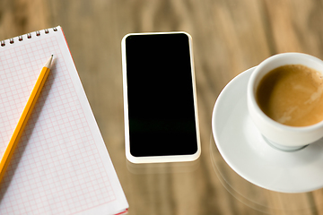 Image showing Mock up empty black smartphone screen on wooden table background