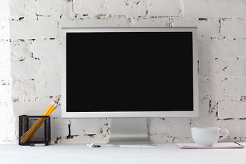 Image showing Mock up empty black monitor screen on white brick wall background