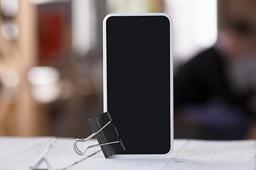 Image showing Mock up empty black smartphone screen on blured background