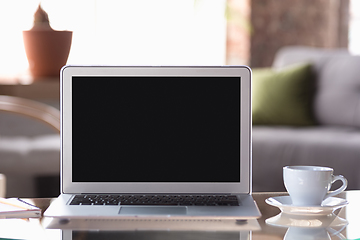 Image showing Mock up empty black laptop screen on blured background