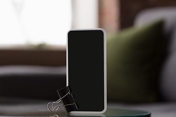 Image showing Mock up empty black smartphone screen on blured background