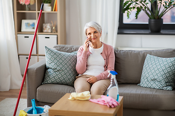 Image showing old woman calling on cellphone after cleaning home