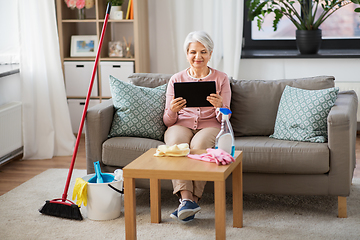 Image showing senior woman using tablet pc after cleaning home