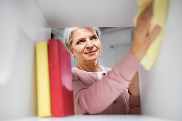 Image showing happy senior woman with cloth dusting rack at home