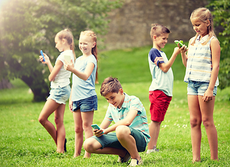 Image showing kids with smartphones playing game in summer park