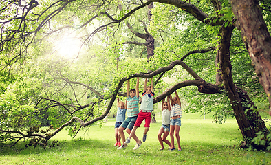 Image showing happy kids hanging on tree in summer park