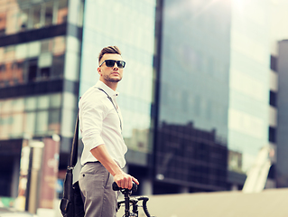 Image showing young man with bicycle on city street